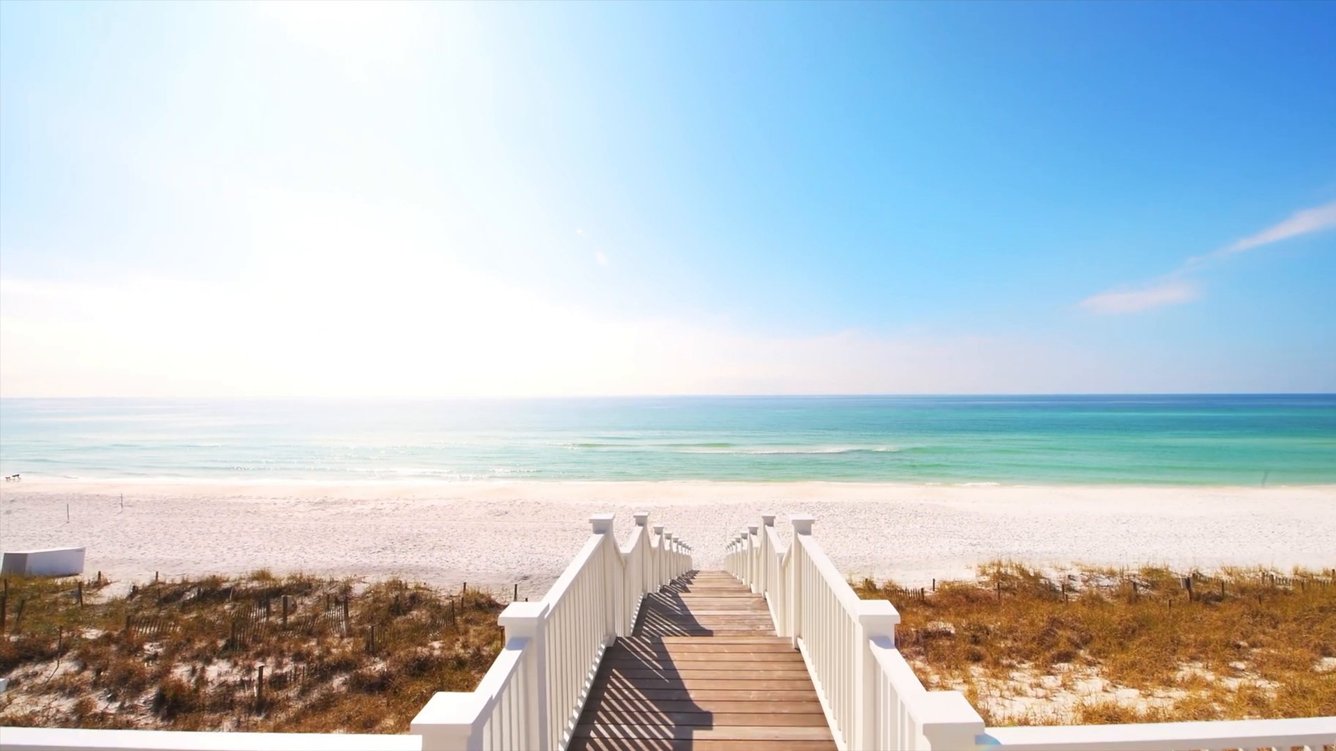 A white boardwalk leading down to the white sand beach and turquoise water at 30A, Seaside, Florida